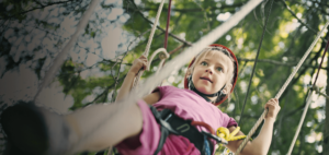 young girl on outdoor aerial course
